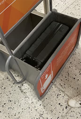 Valise noire dans un gabarit de taille à l'aéroport.